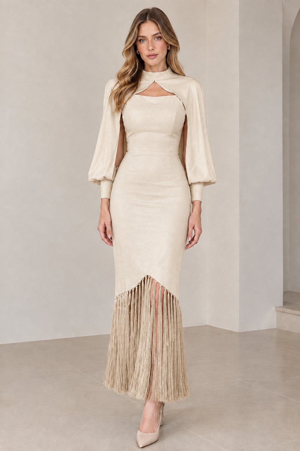 Model wearing champagne beige high neck cape sleeve midi dress with matching fringe