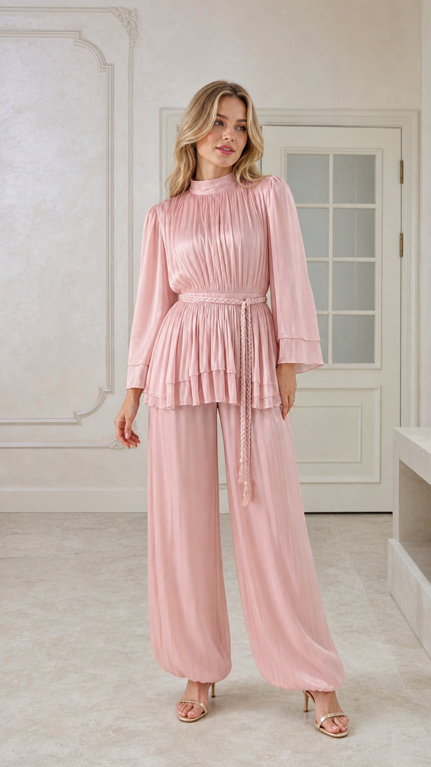 Front view of woman wearing blush pink pleated tunic top and matching trousers set