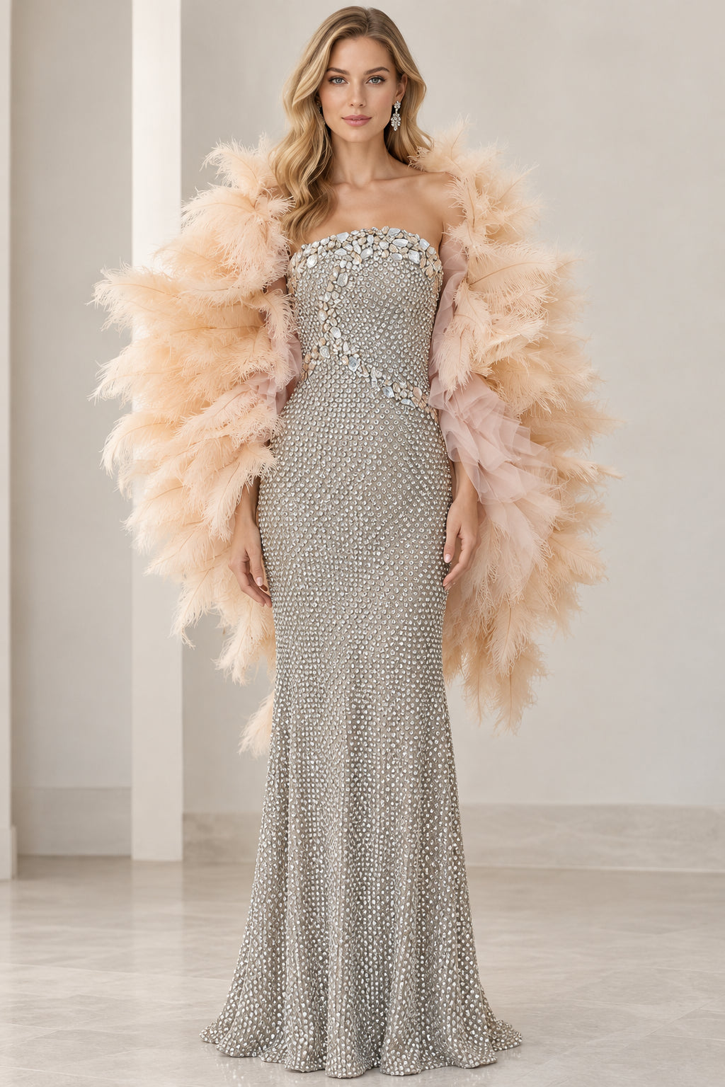 Front view of model wearing a sparkling silver strapless rhinestone evening gown with a voluminous beige feather shawl