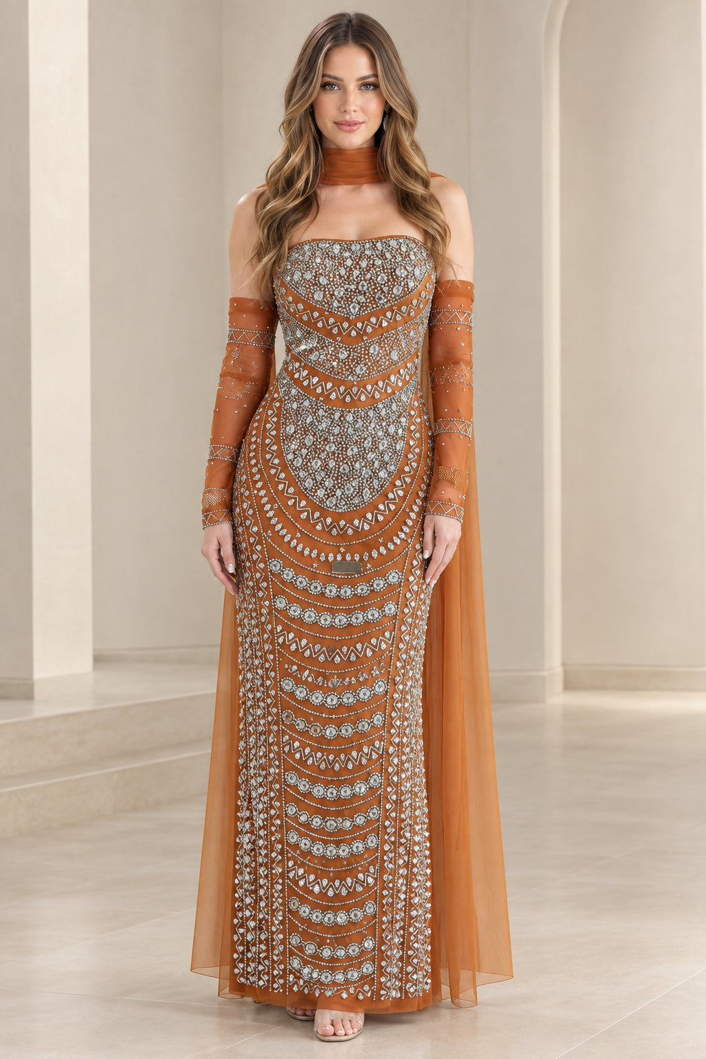 Front view of model wearing rust orange beaded strapless evening gown with sheer cape sleeves