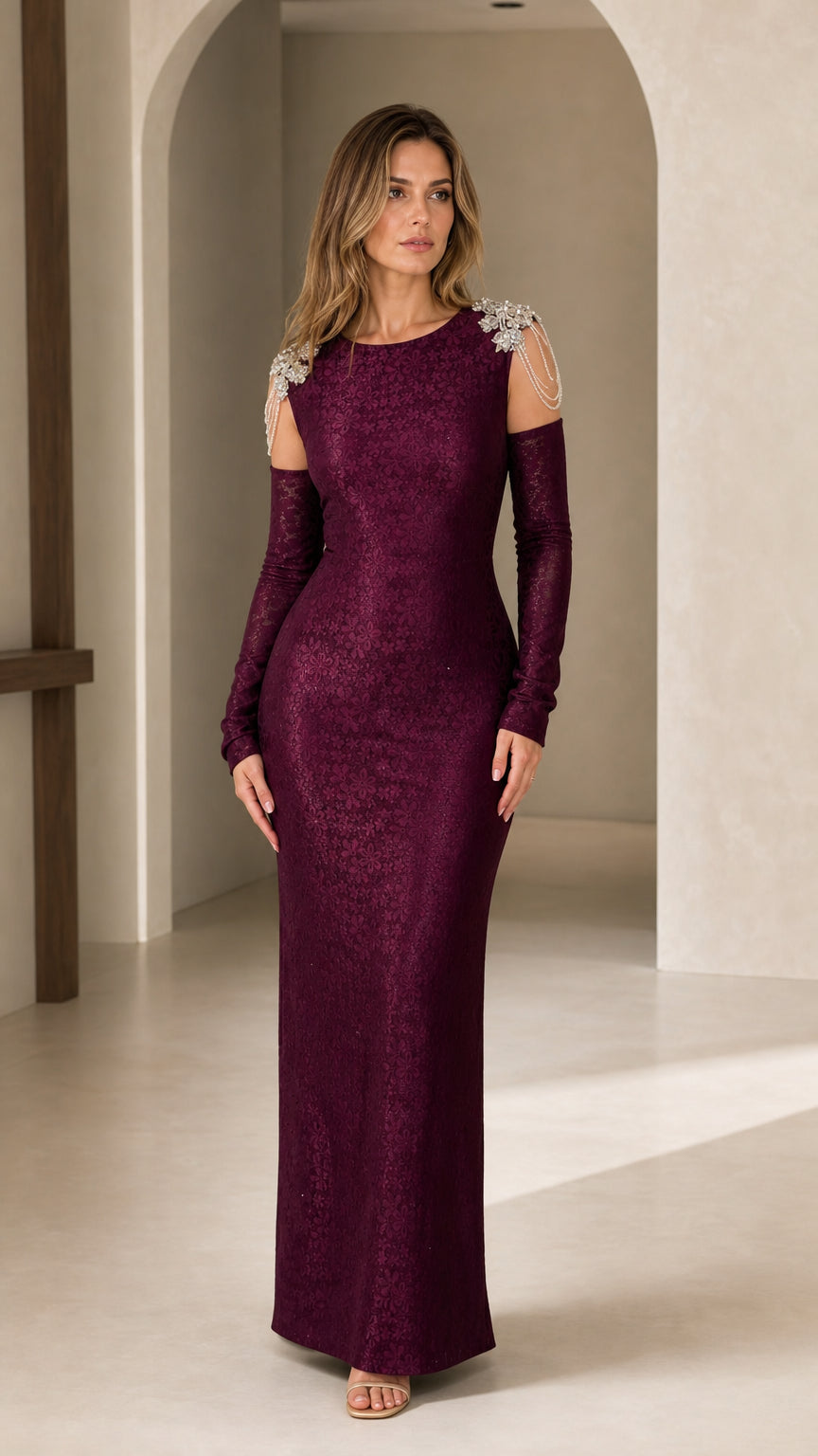 Front full-length view of woman in burgundy cold-shoulder evening gown with crystal shoulder embellishments