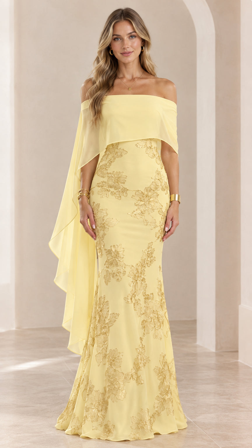 Front view of woman wearing yellow off-the-shoulder cape evening gown with floral embroidery