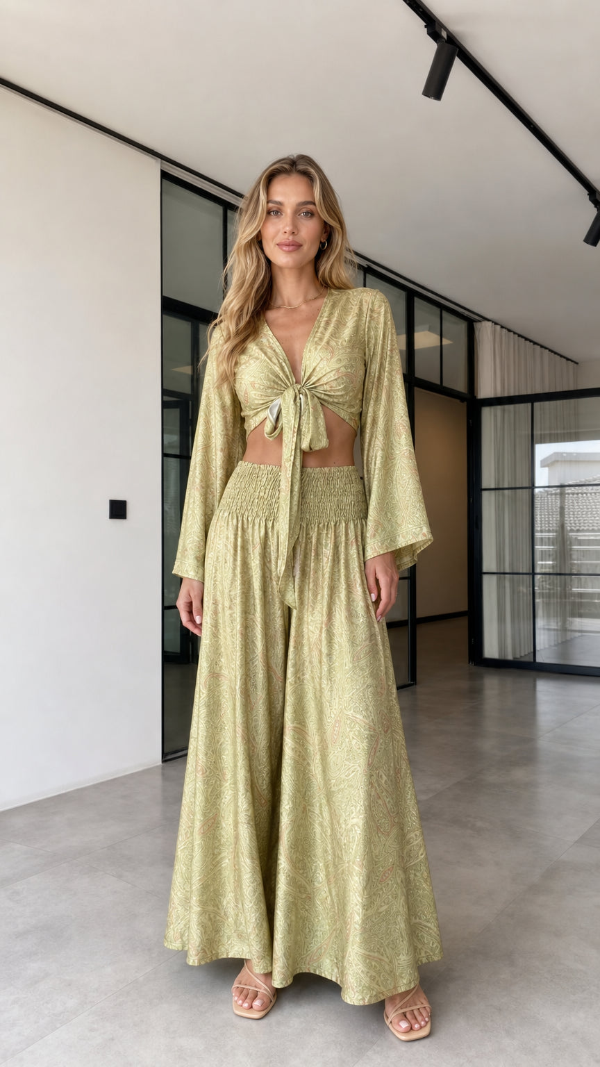 Model wearing the olive gold paisley-inspired tie-front crop top and wide-leg pants set from the front
