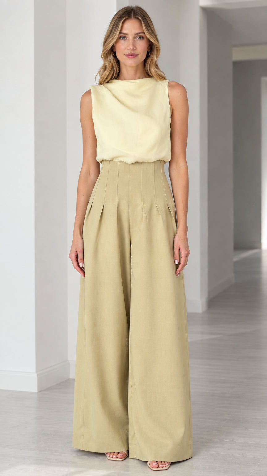 Front view of model wearing sleeveless draped top and wide-leg pleated jumpsuit in butter yellow and khaki
