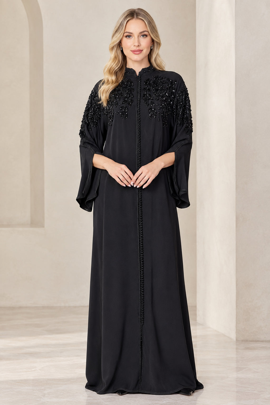 Front view of woman wearing full-length black beaded shoulder abaya dress