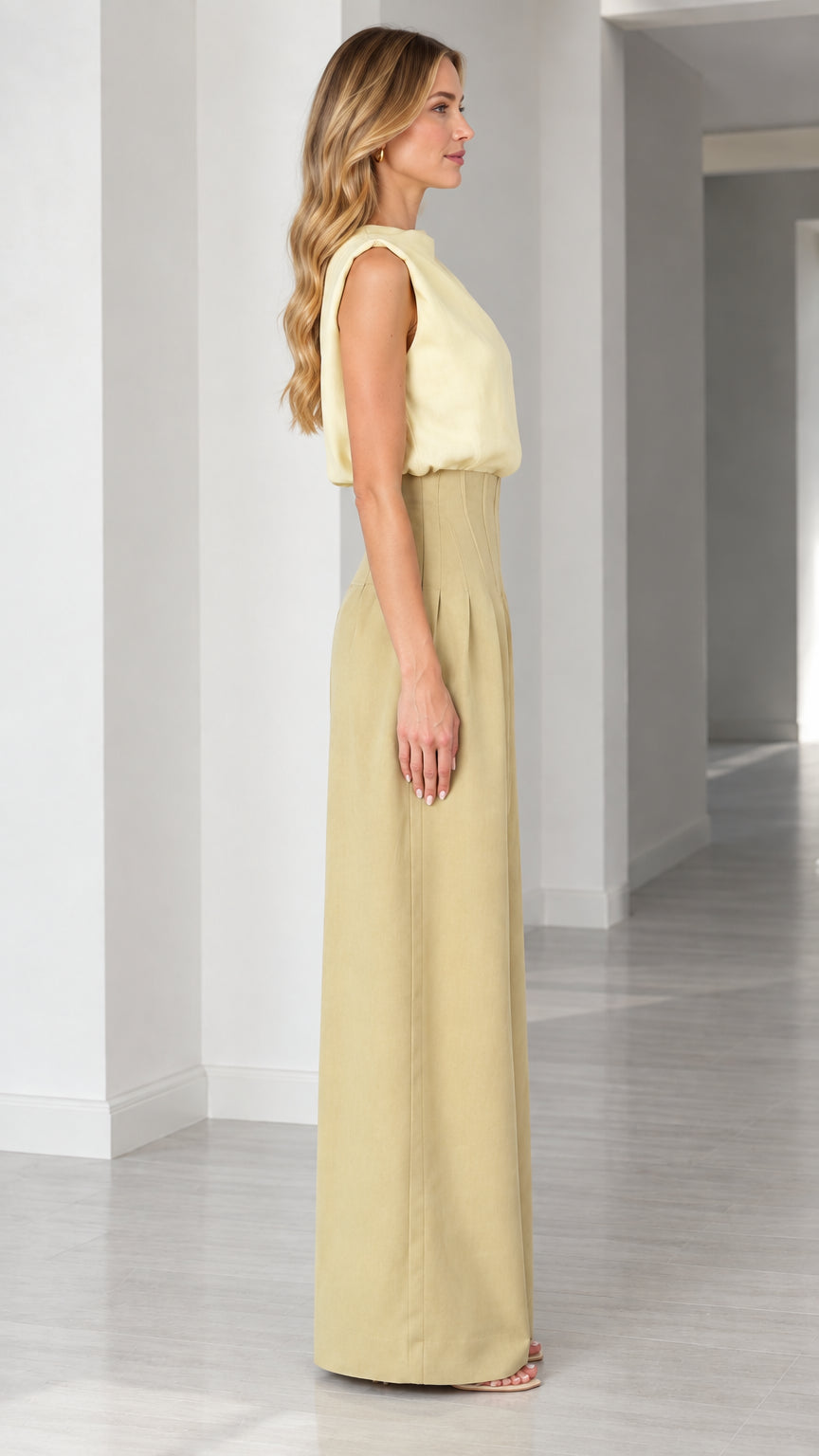 Side profile of model wearing high-waist wide-leg jumpsuit in butter yellow and khaki