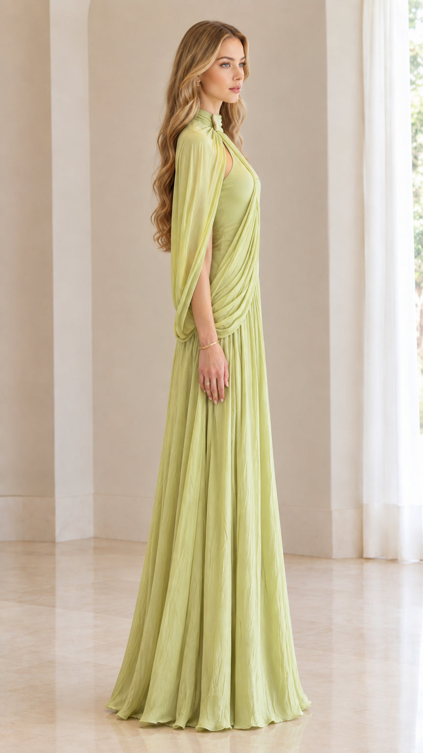 Side profile of woman wearing sage green pleated high-neck cape evening dress