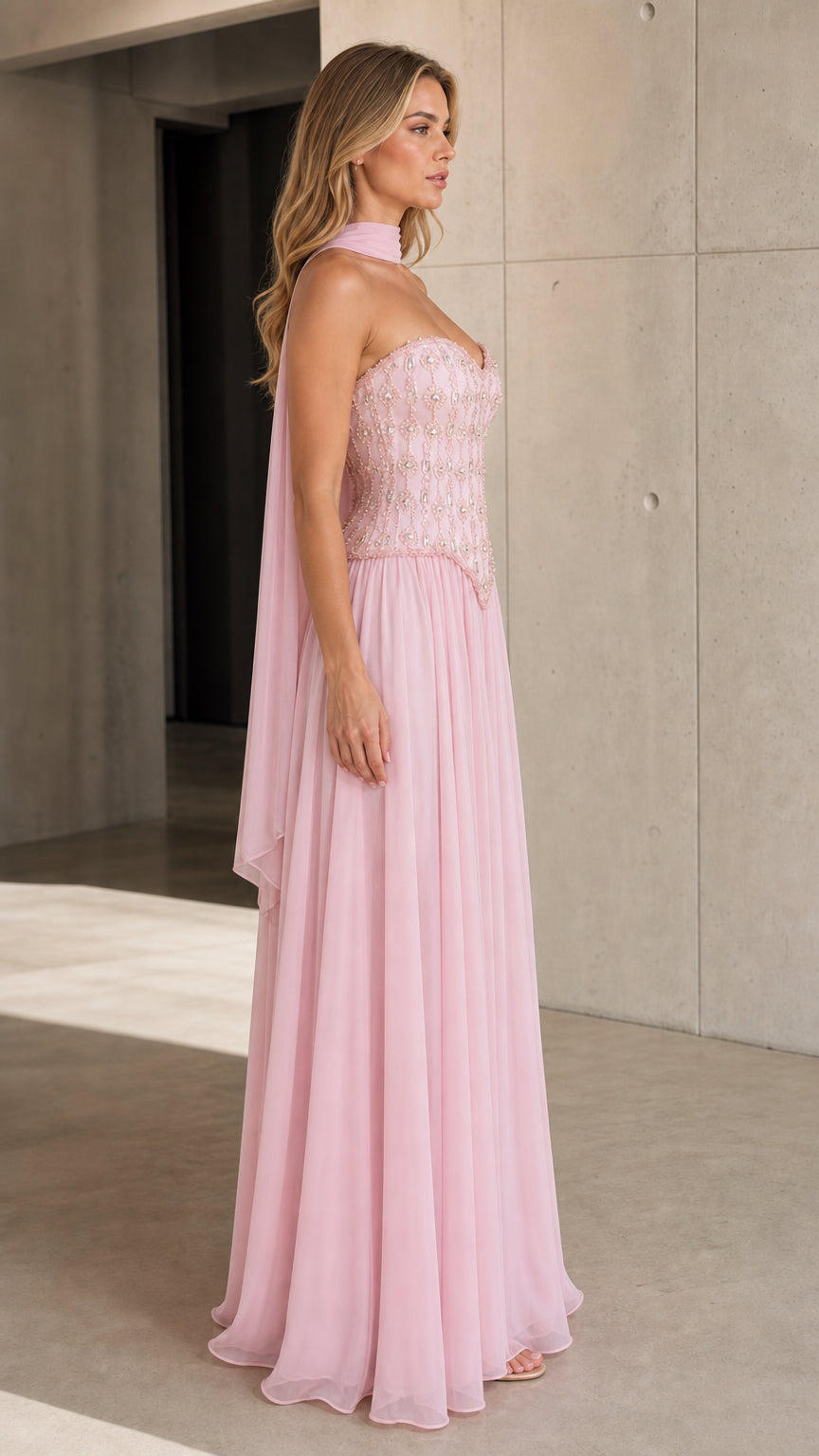 Side view of model wearing Light Pink embellished strapless evening dress with neck scarf