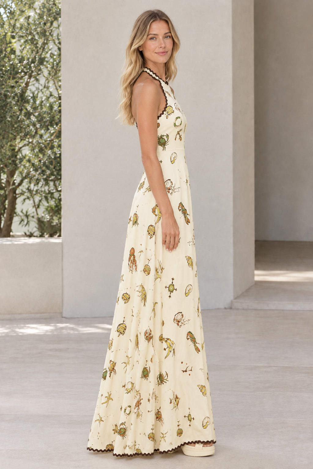 Side profile view of cream nautical print sleeveless maxi dress