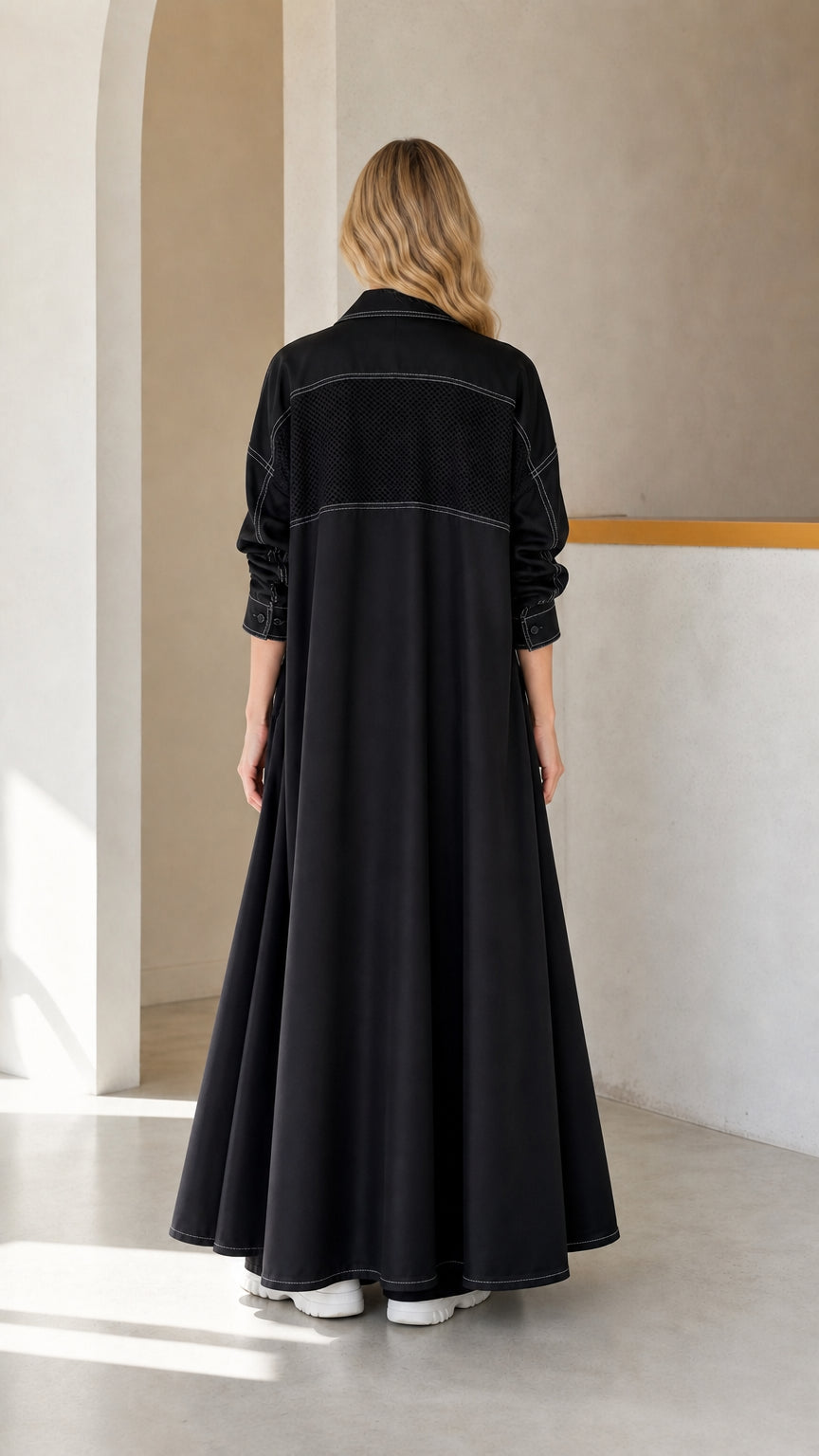 Back view of woman in Black maxi duster coat featuring textured back yoke detail