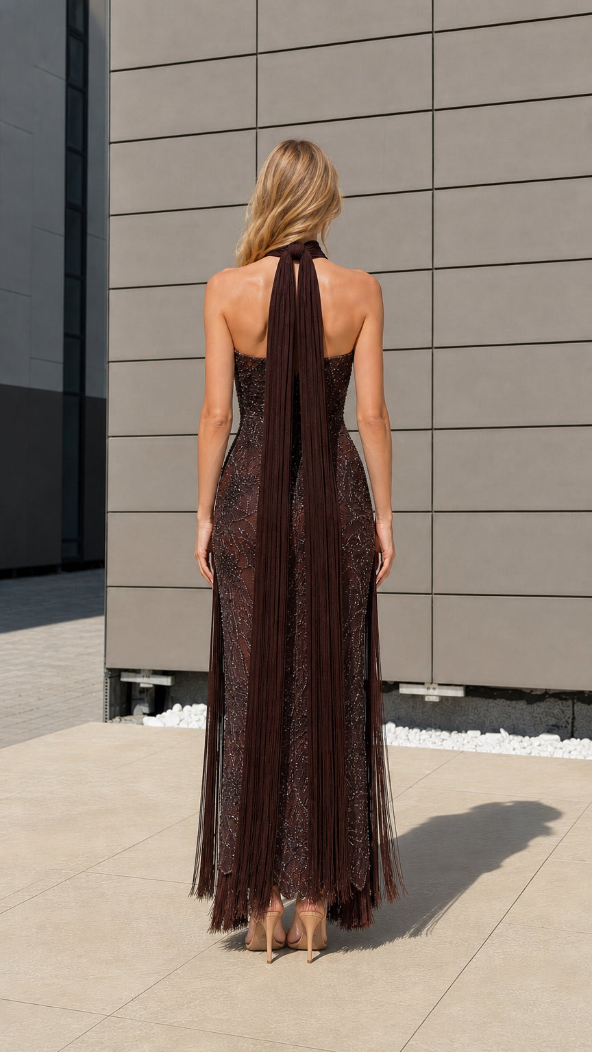 Back view of model showcasing long halter neck drapes on brown gown