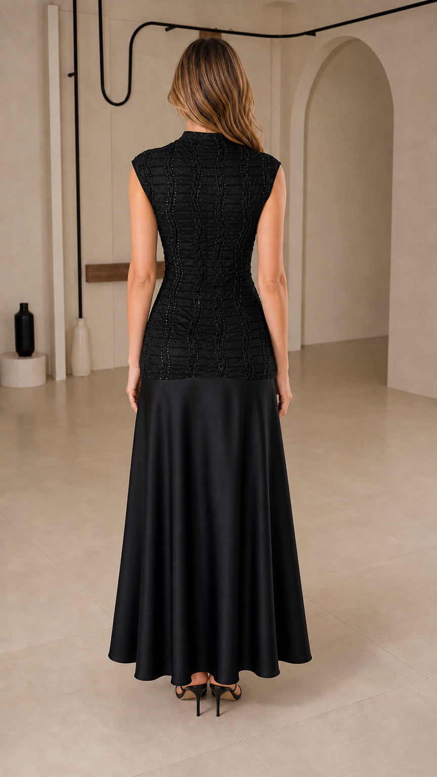 Back view of model wearing black mock neck drop-waist satin maxi evening dress