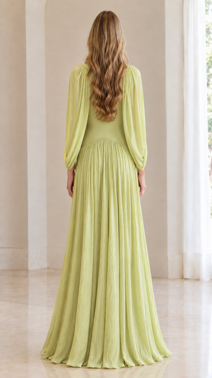 Back view of woman wearing sage green pleated maxi formal dress with cape sleeves