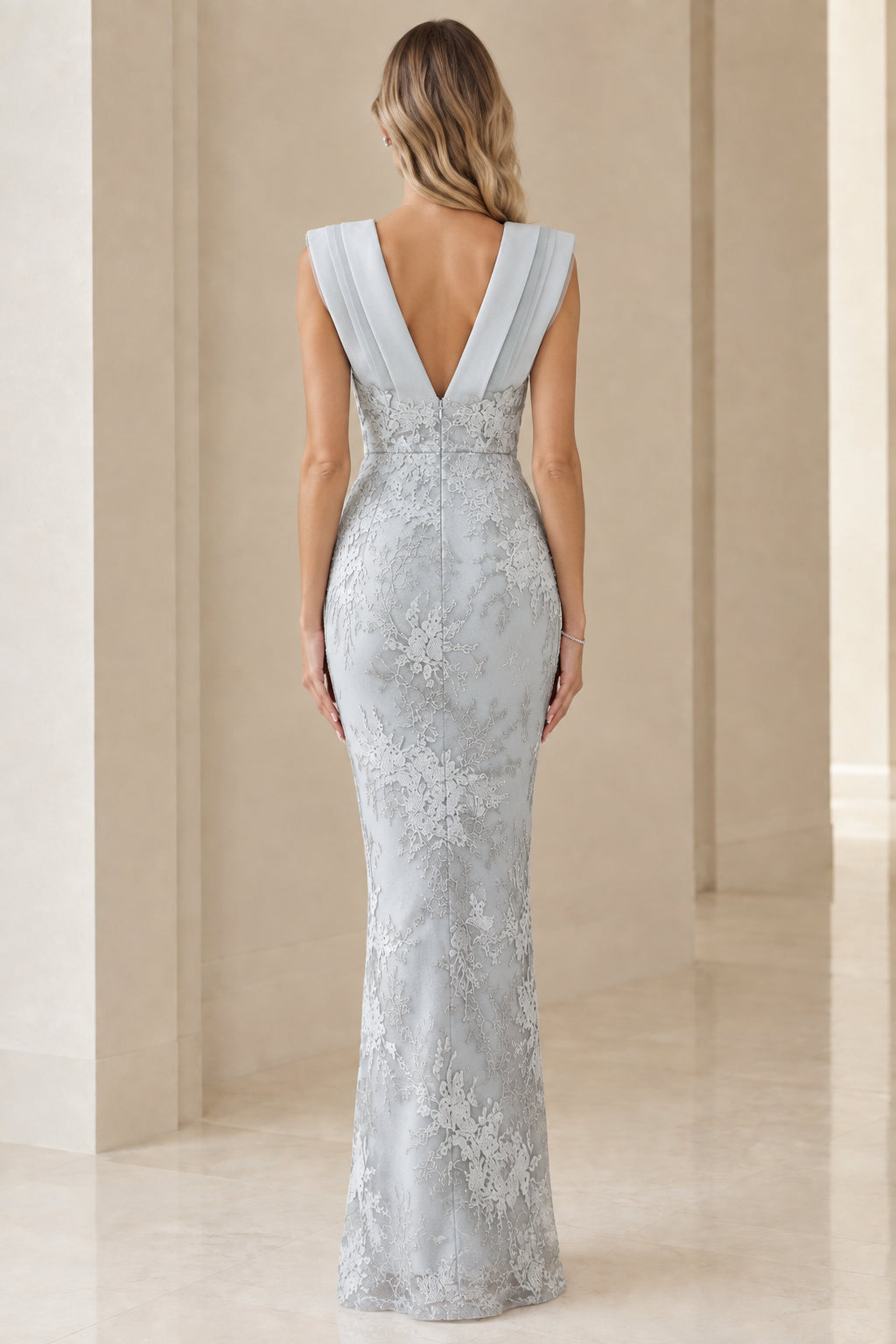 Back view of model in dusty blue evening dress showing deep V-back and zip closure