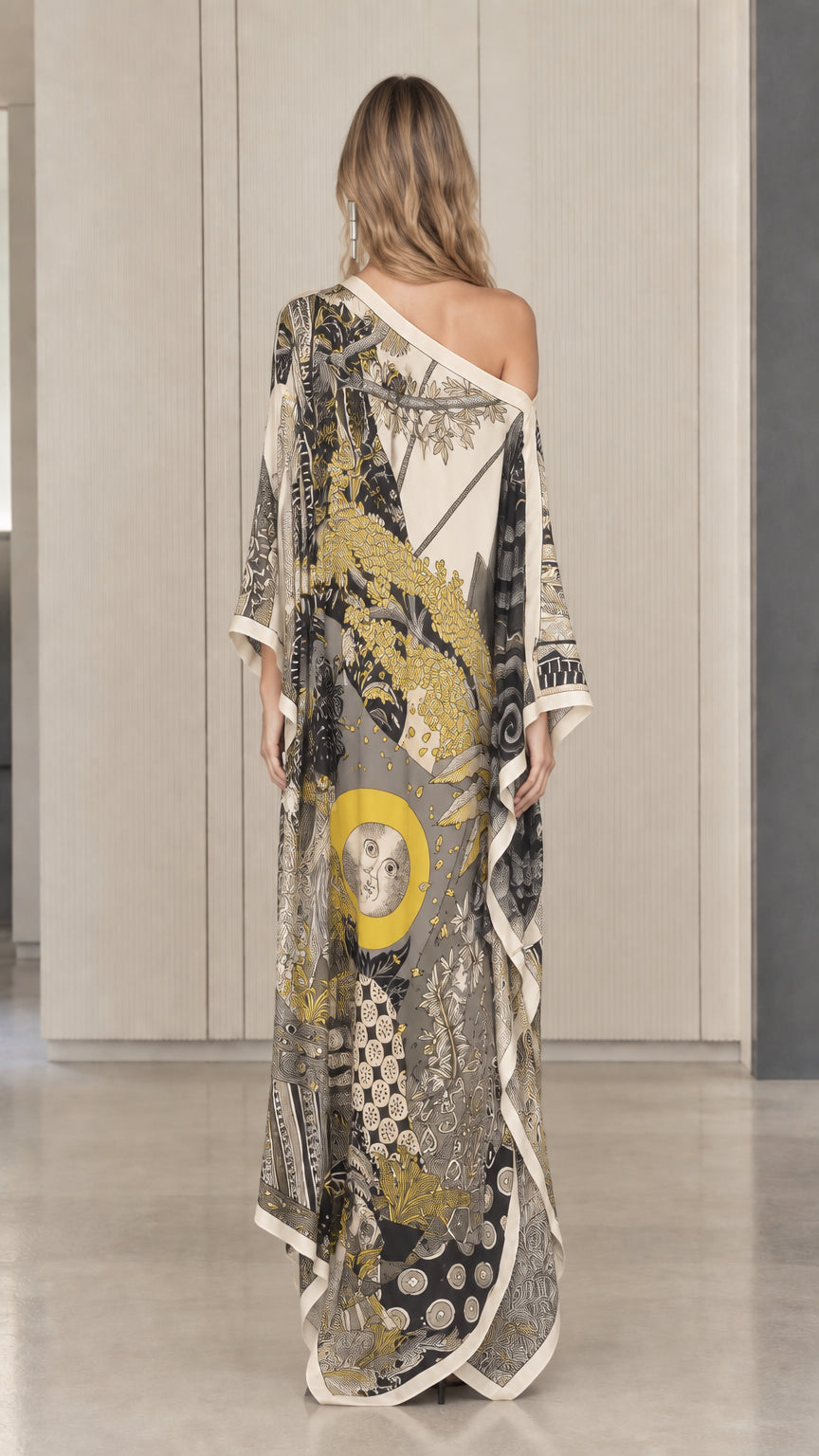 Back view of model in ivory one-shoulder printed flowing kaftan dress