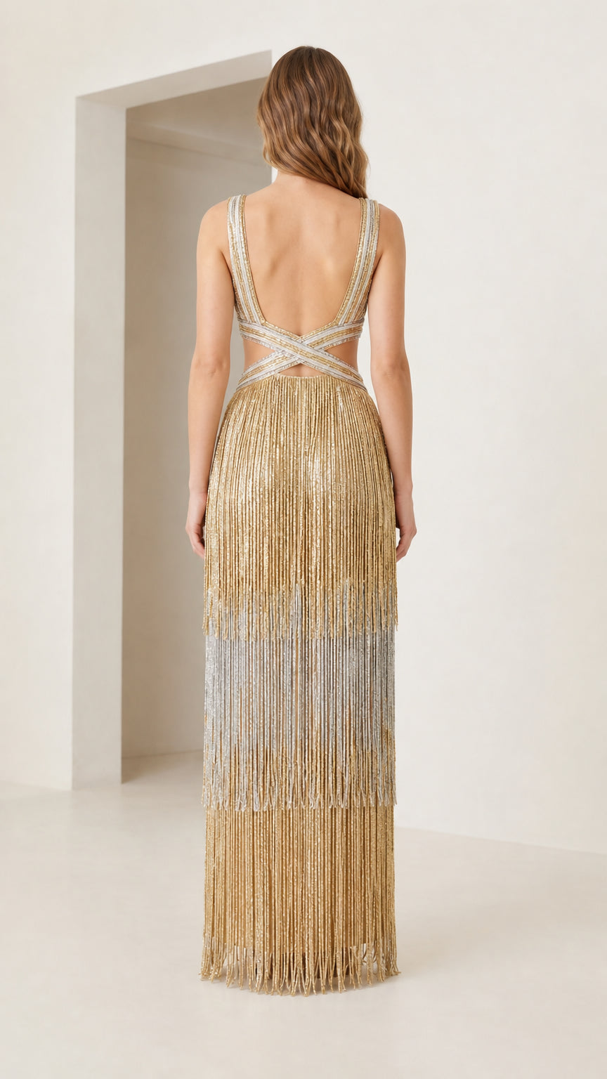Back view of model showing open back detail of gold tiered fringe maxi dress