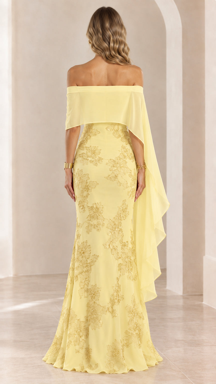 Back view of woman wearing yellow off-the-shoulder cape evening gown