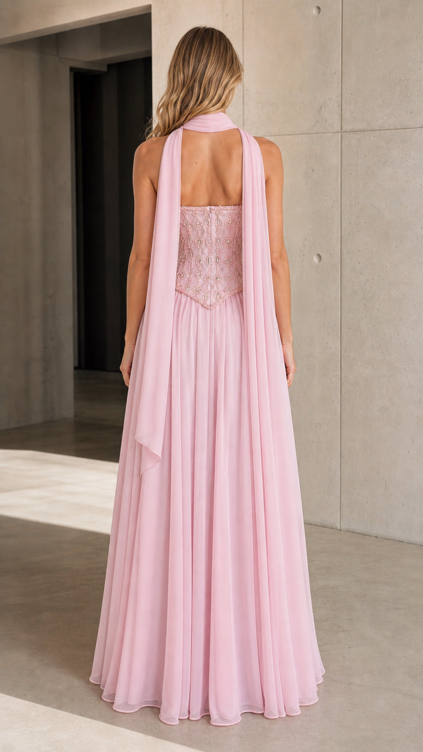 Back view of model wearing Light Pink formal gown showing flowy chiffon drape and back closure