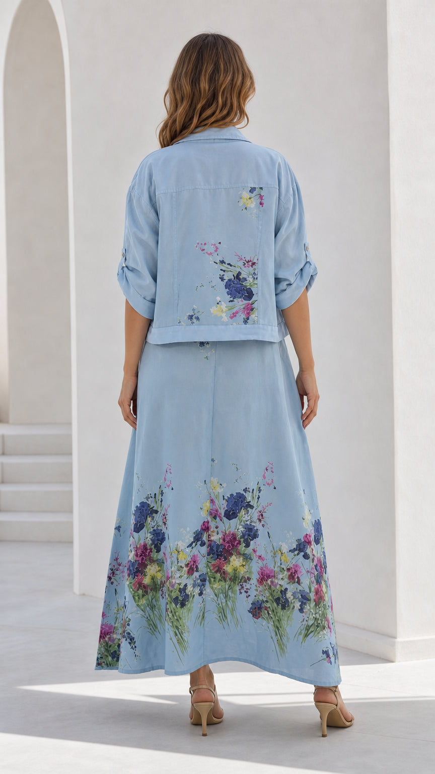 Back view of sky blue floral print cropped jacket and long maxi skirt set