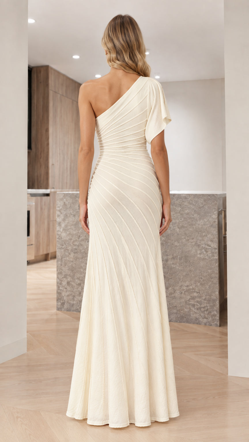Back view of woman in ivory one-shoulder pleated formal gown