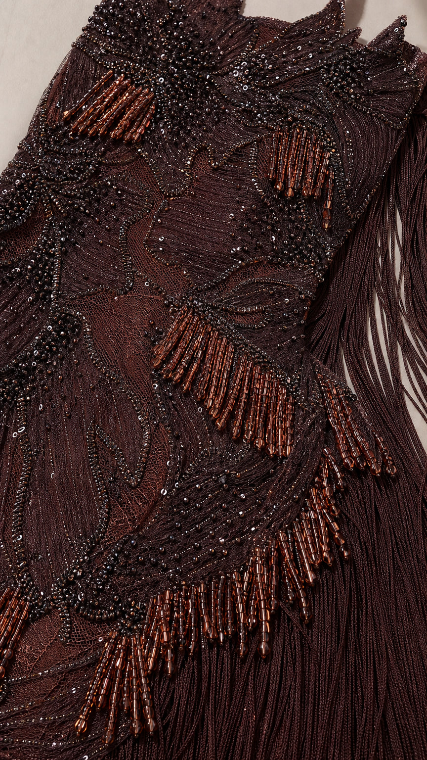 Close-up detail of intricate brown bead embroidery and fringe