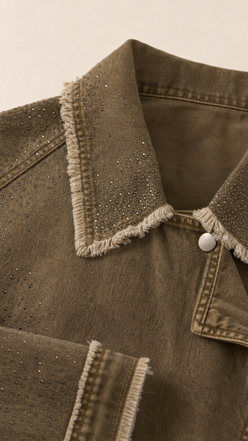 Close-up detail of rhinestone embellishments and frayed collar on twill jacket