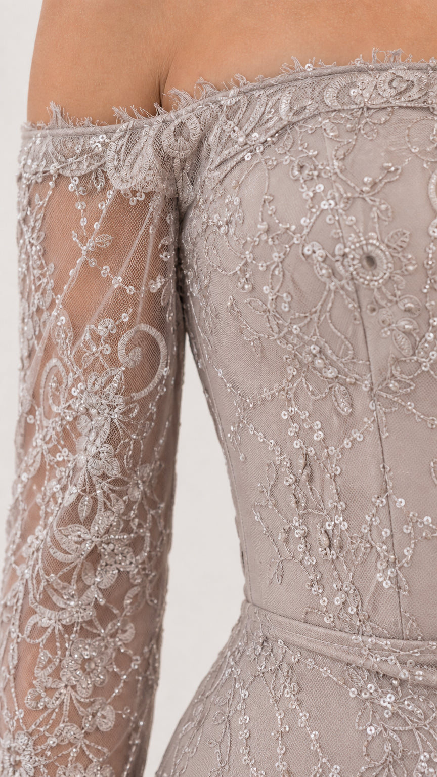 Close-up detail of sheer mesh sleeve with sequin floral embroidery and eyelash lace neckline