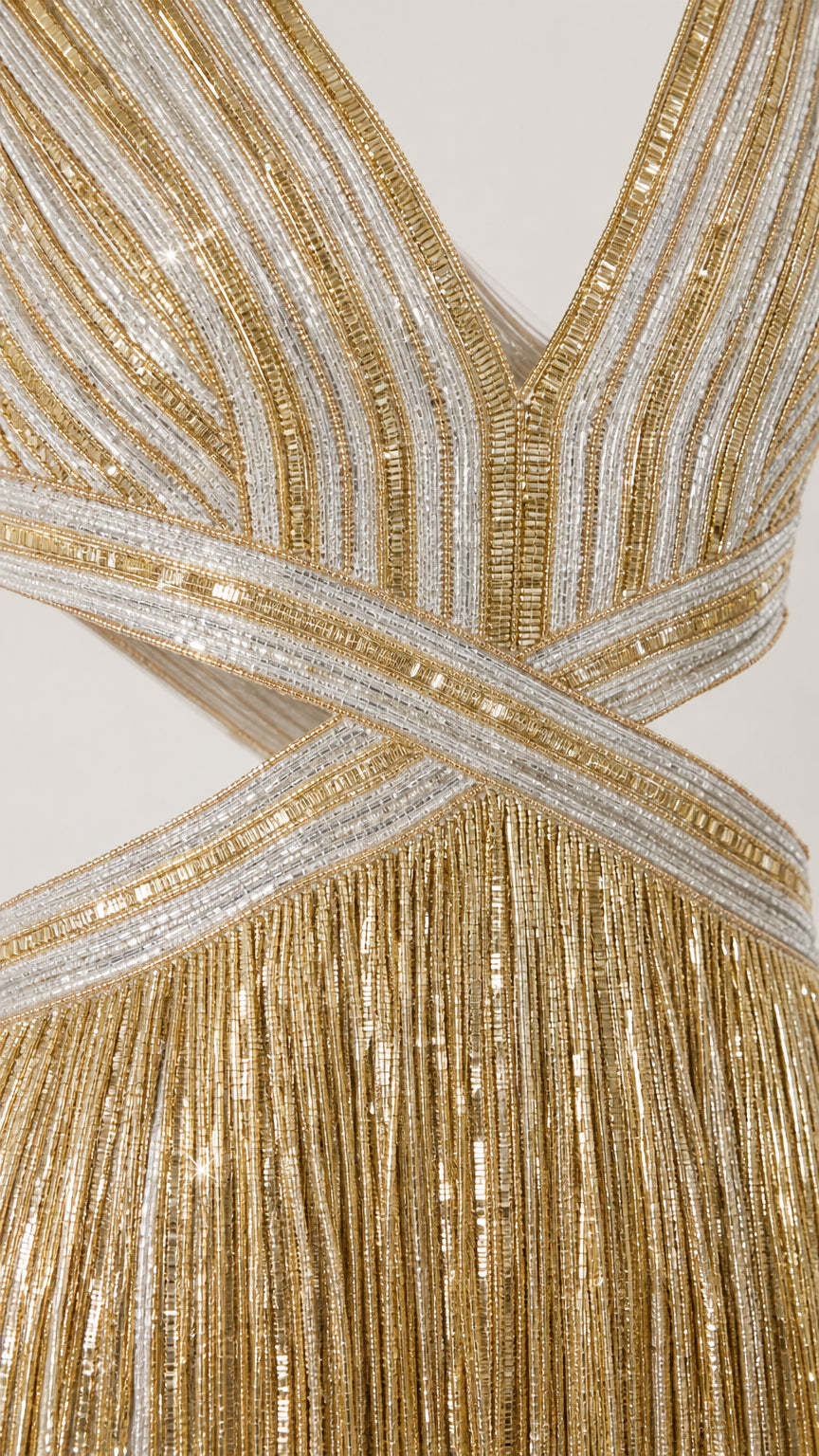 Close-up detail of metallic striped bodice and waist cutouts on gold fringe gown