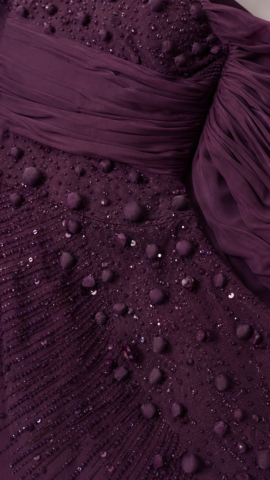 Close-up of intricate dark plum beading, sequins, and ruched draped sleeve detail