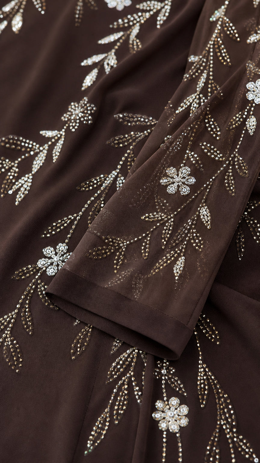 Close-up detail of shimmering floral and vine rhinestone embellishments on chiffon fabric