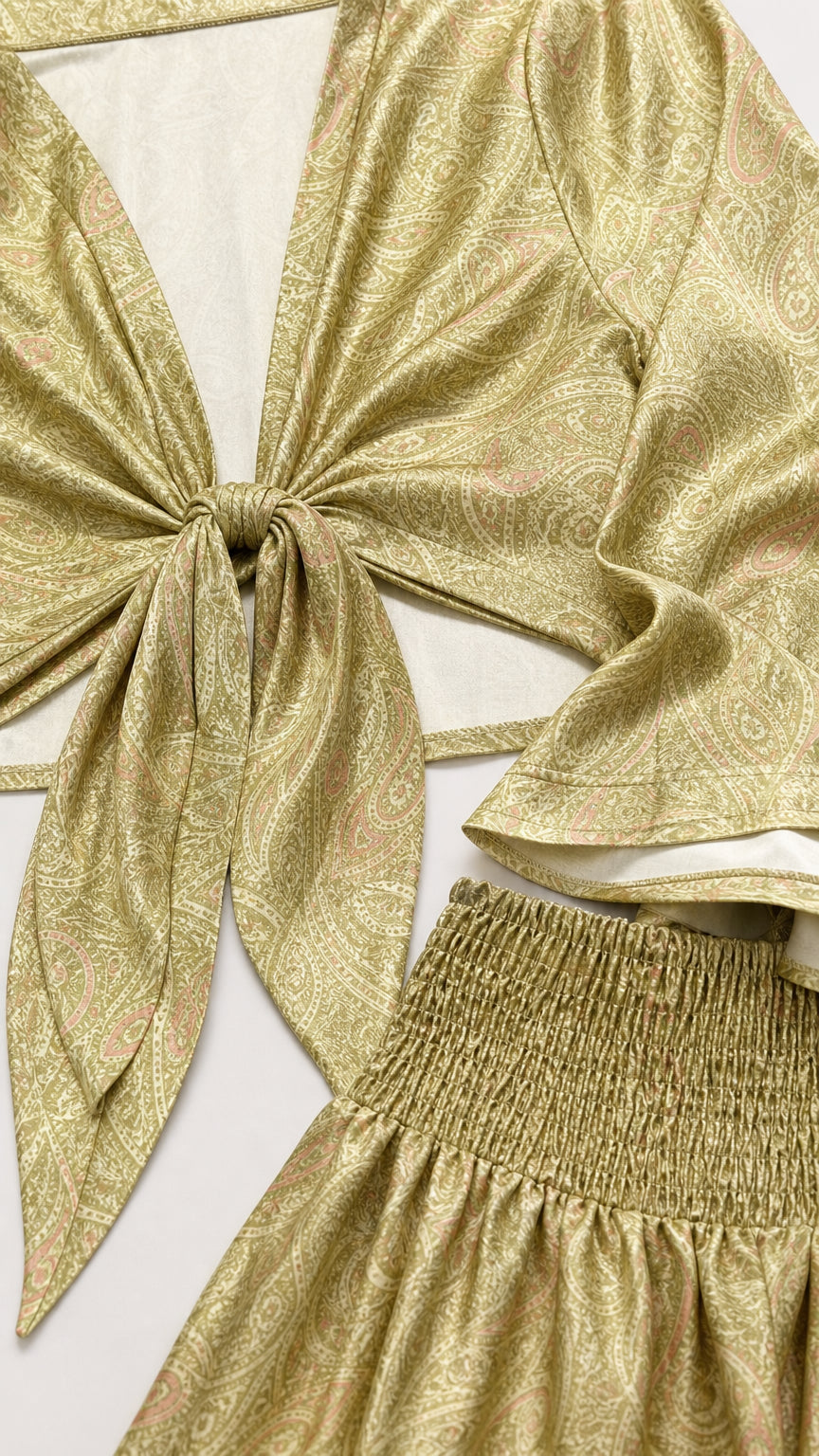 Close-up of the olive gold paisley-inspired fabric, front tie, and shirred waistband
