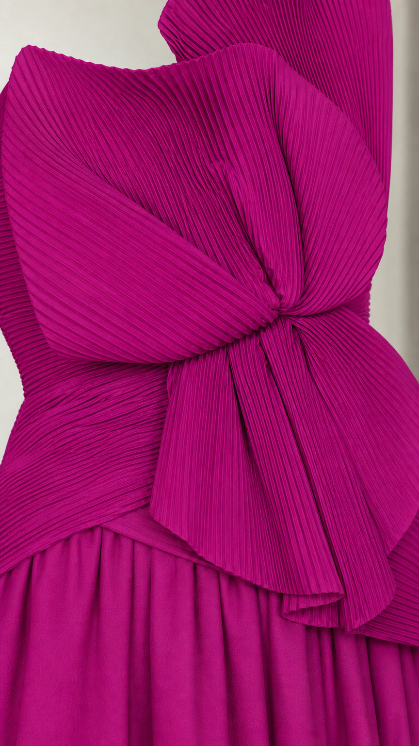 Close-up detail of the accordion-pleated statement bow on the bodice of the gown