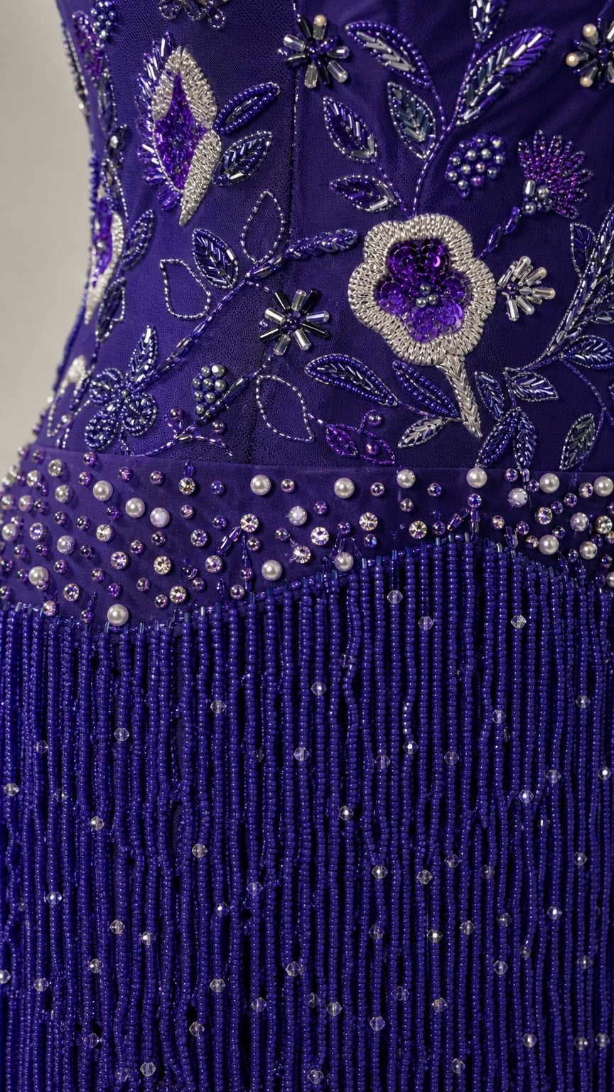 Close-up detail of royal blue floral beadwork, sequins, and cascading fringe trim