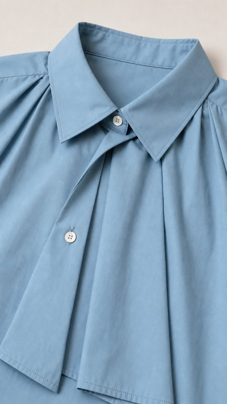 Close-up detail of point collar and front pleats on blue shirt