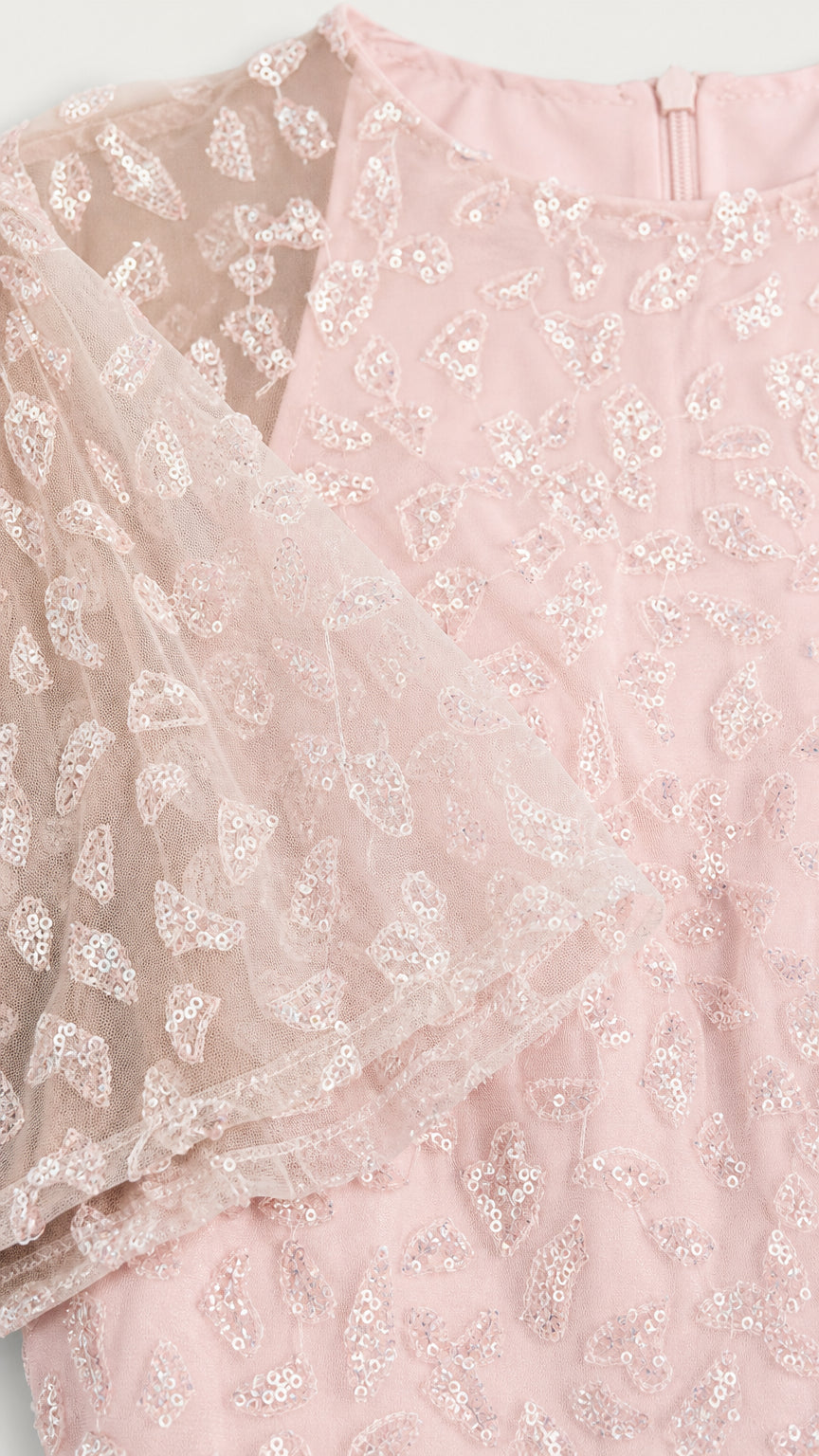 Close-up detail of blush pink sequin embroidery and sheer mesh sleeve fabric