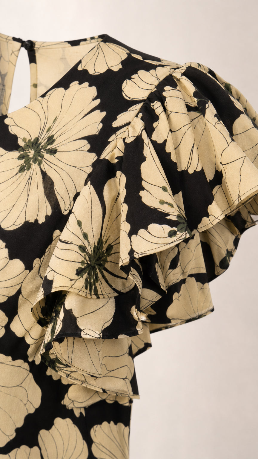 Close-up detail of tiered ruffled flutter sleeves and floral print on black dress