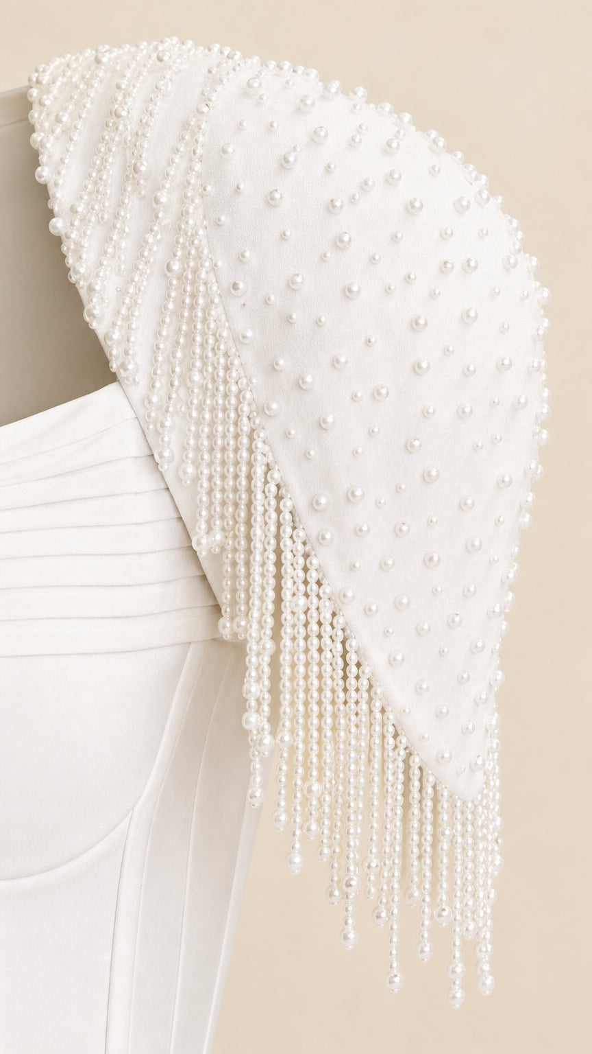 Close-up detail of white faux pearl and beaded fringe shoulder wrap