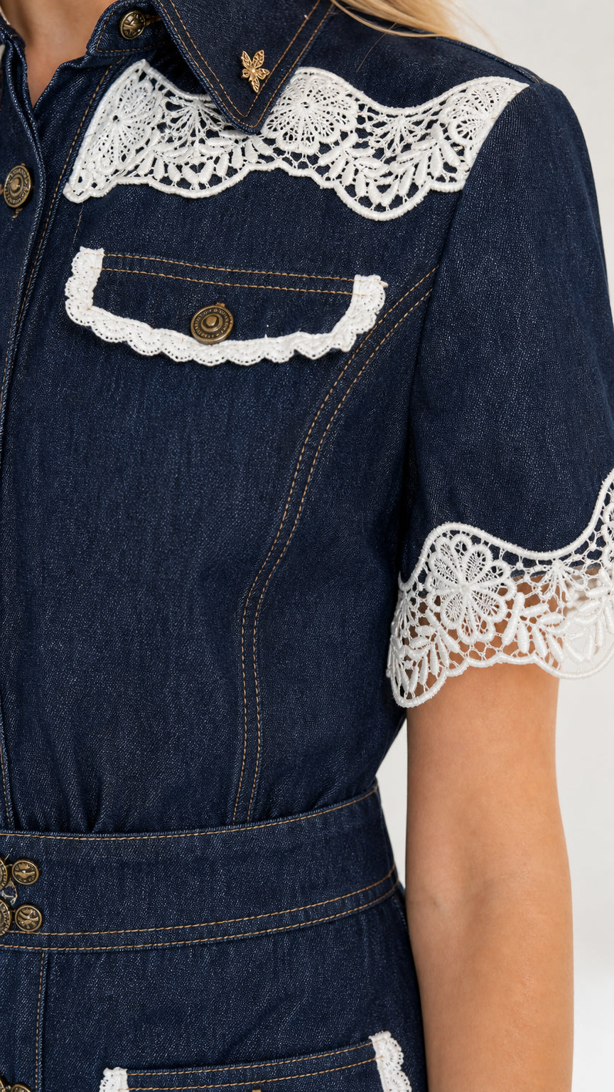Close-up detail of white crochet lace yoke, collar, and buttoned pocket on denim dress