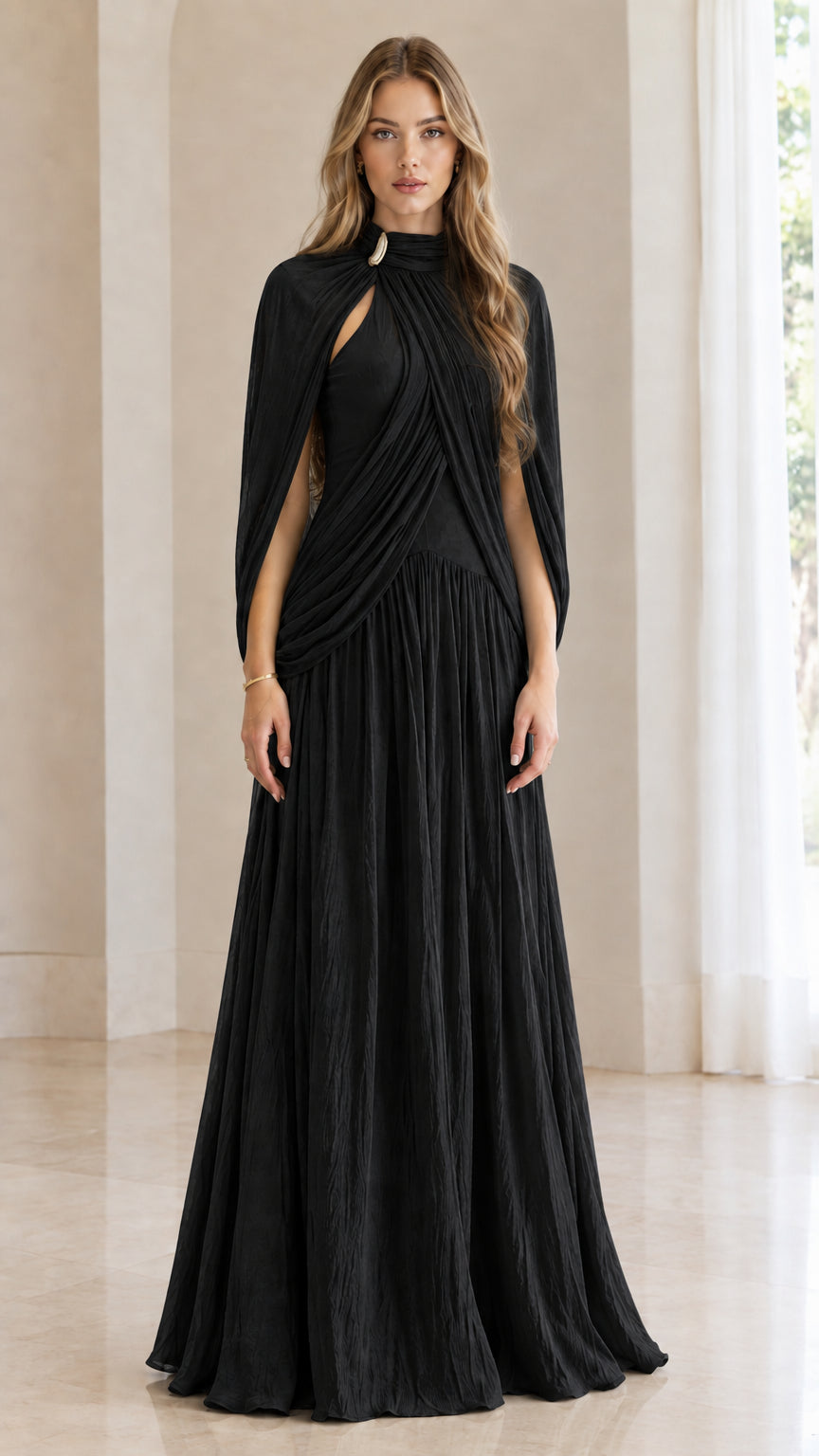 Front full-length view of woman wearing black pleated cape-sleeve maxi evening dress