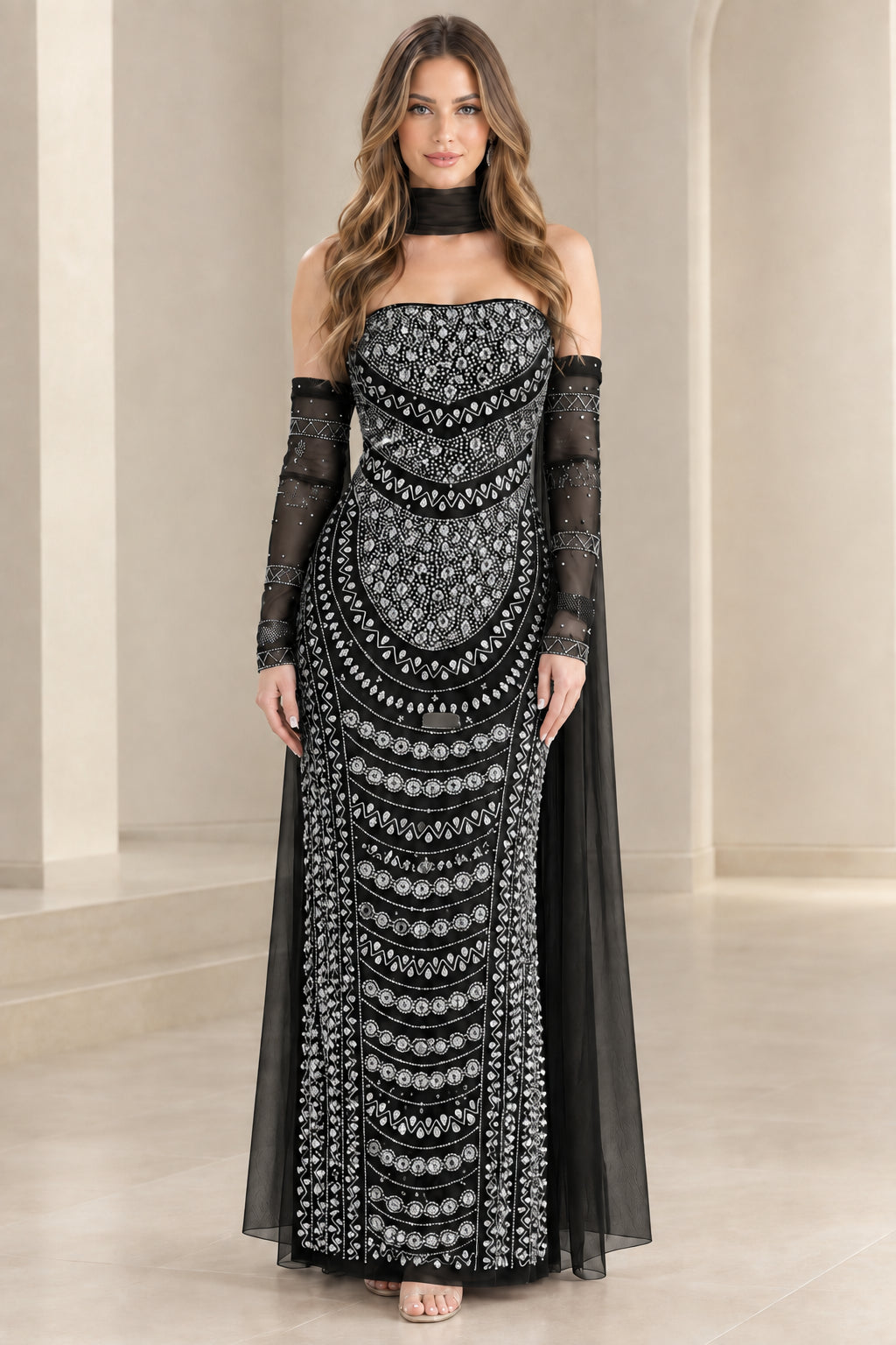 Model wearing black beaded strapless evening gown with matching choker and cape sleeves