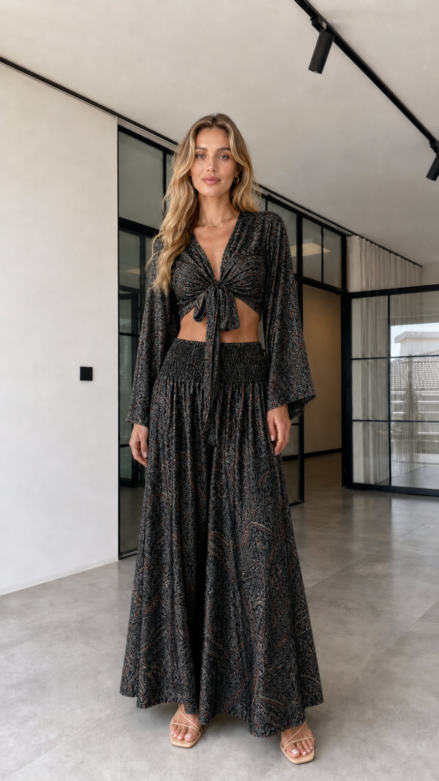 Model wearing the black paisley-inspired tie-front crop top and wide-leg pants set