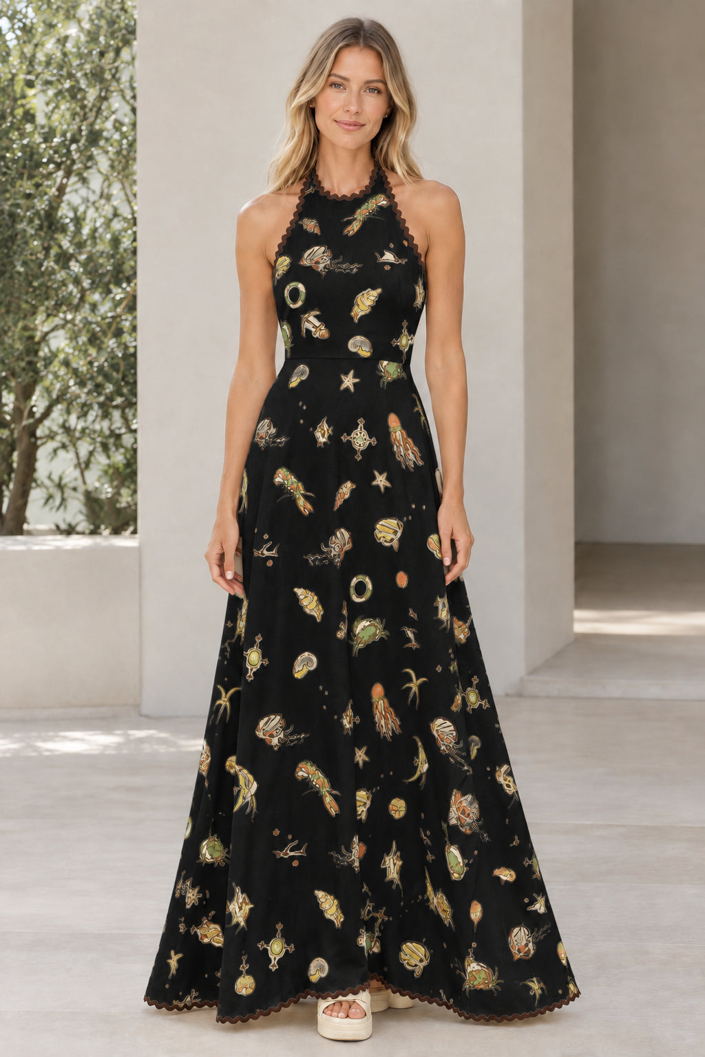 Model wearing black marine print halter maxi dress with contrast trim