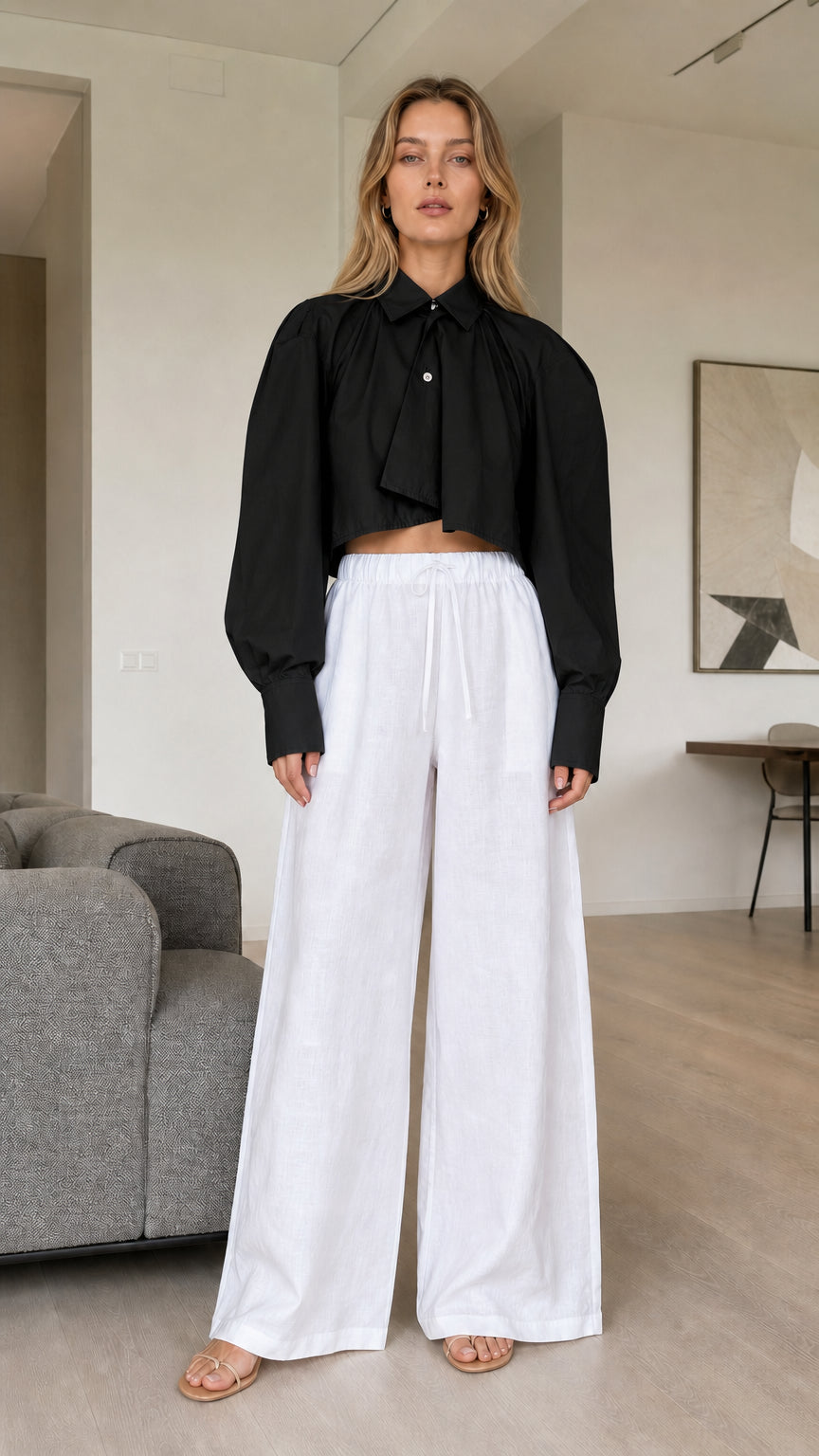 Model wearing black cropped pleated button-down shirt
