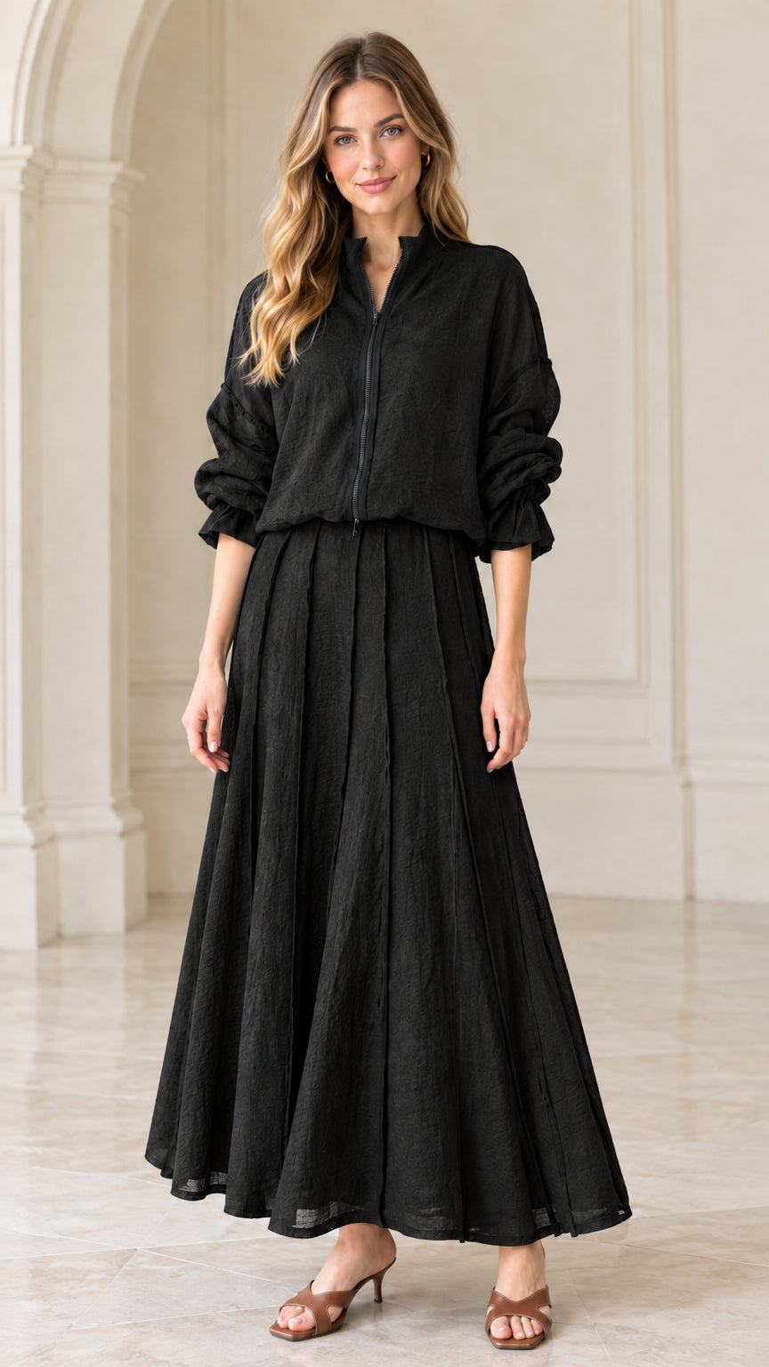 Full front view of black textured zip-up blouse and pleated maxi skirt set