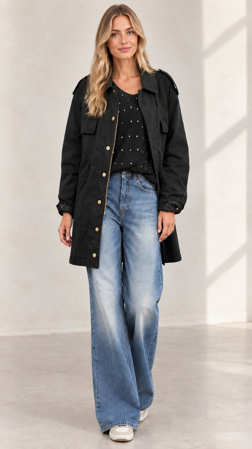 Full front view of women's black mid-length utility jacket with jeans