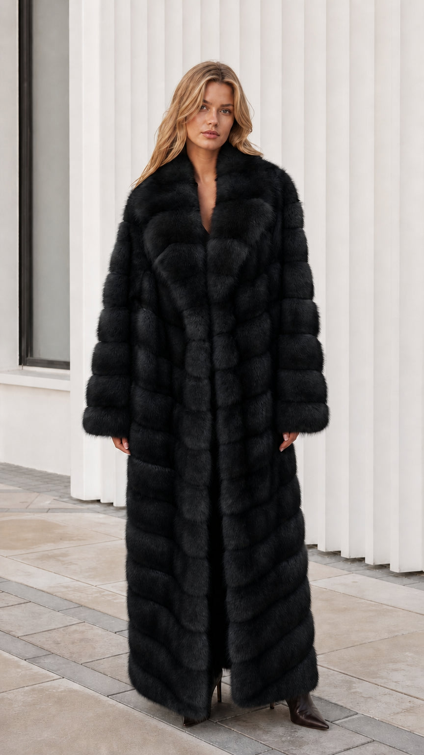 Front view of model wearing classic black full-length faux fur maxi coat