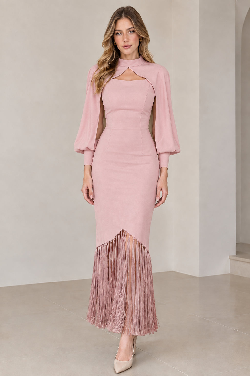 Model wearing dusty pink high neck cape sleeve midi dress with matching pink fringe