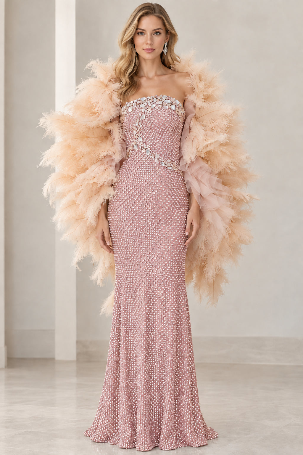 Front view of dusty rose strapless beaded formal gown with blush feather wrap