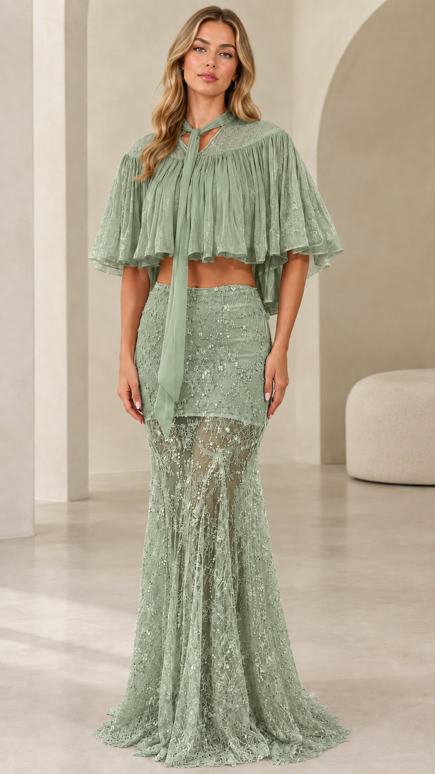 Model wearing sage green sequin lace maxi dress set with flowing capelet