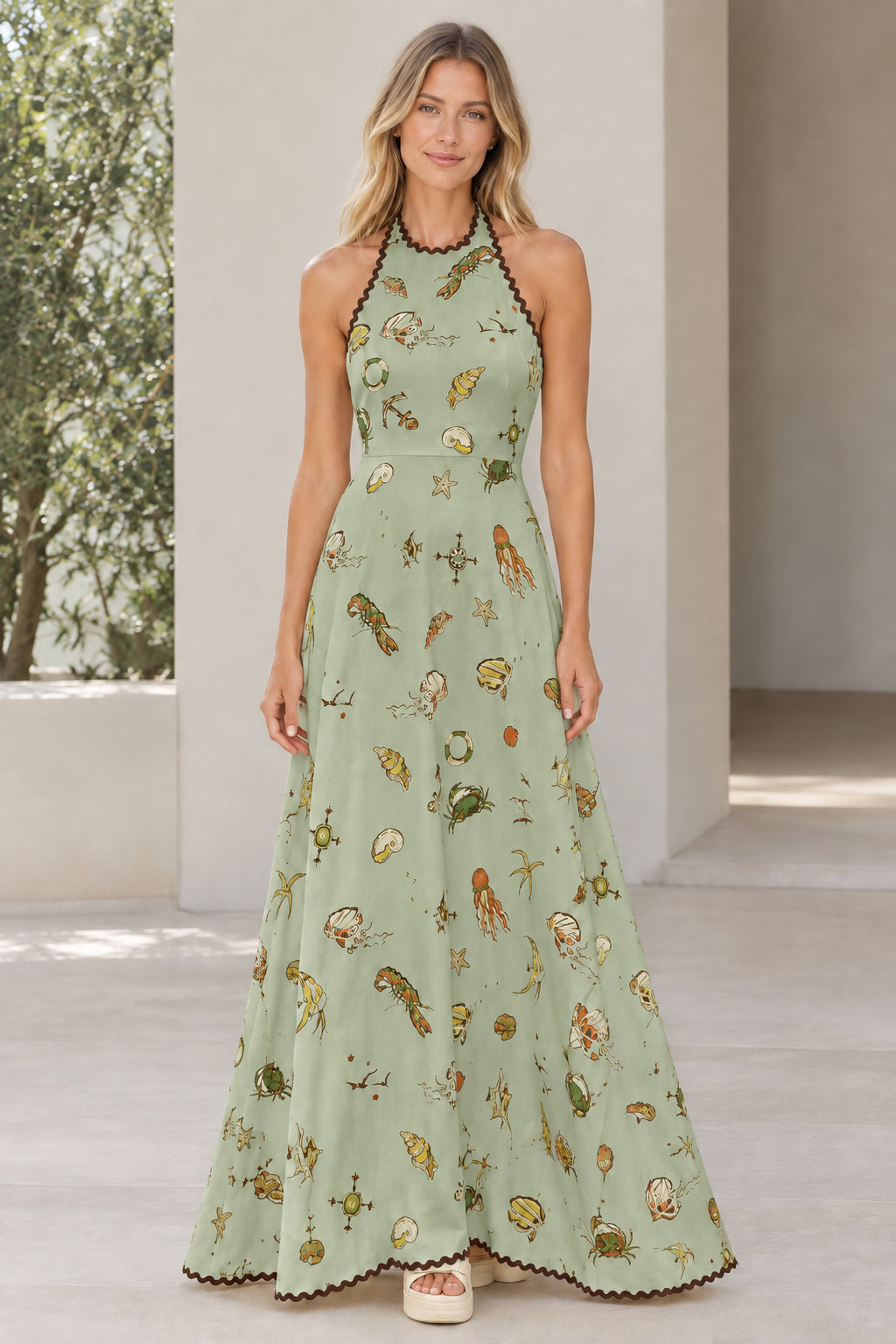 Model wearing sage green nautical print halter maxi dress